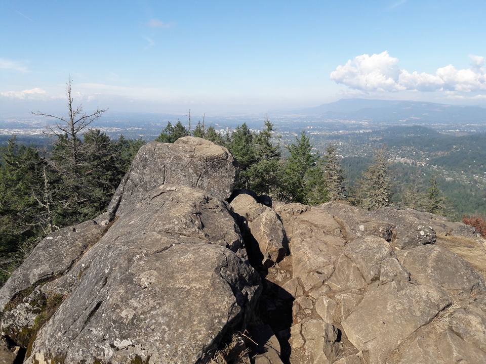 view from the top of a rocky butte overlooking the city of Eugene, Oregon, one big fluffly cloud in the blue sky